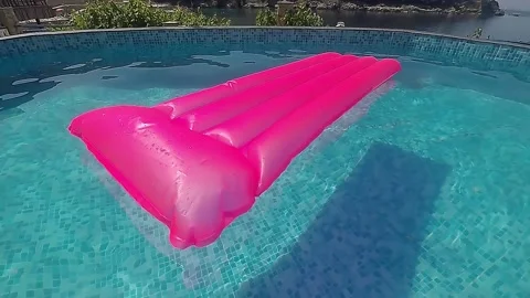 Pink rubber mattress in the pool Stock Footage 137114080
