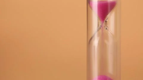 Pink Sand passes, running through hourglass bulbs measuring the transit time Stock Footage 170131750