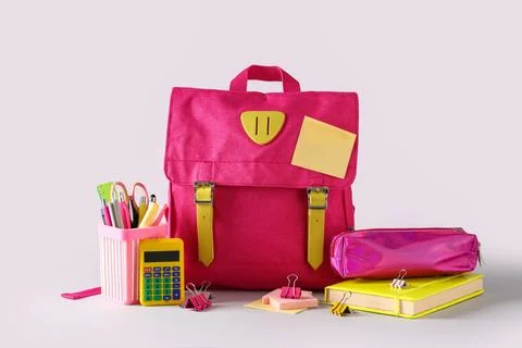 Pink school backpack with different stationery on grey background Stock Photos