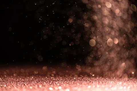 Pink sequins fall on a black background Stock Photos