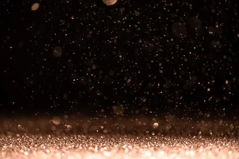 Pink sequins fall on a black background Stock Photos
