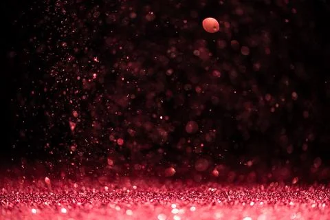 Pink sequins fall on a black background Stock Photos