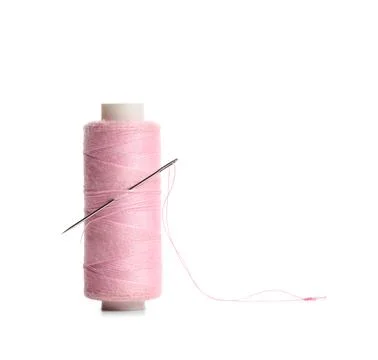 Pink sewing thread spool with needle isolated on white background, closeup Stock Photos