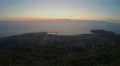 Pink sky above ocean, night city lights, electricity consumption in megalopolis 4k or 4k+ Resolution