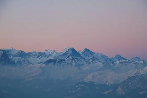 Pink sky over Eiger, Monch and Jungfrau. Sunrise scene in the Swiss Alps. Stock Photos