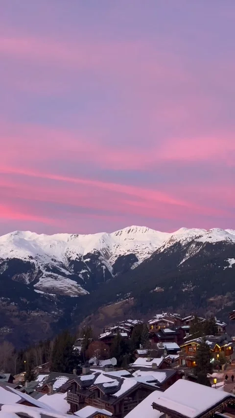 Pink sky over snowcapped mountains in front of Courchevel 1650 Stock Footage 334404206