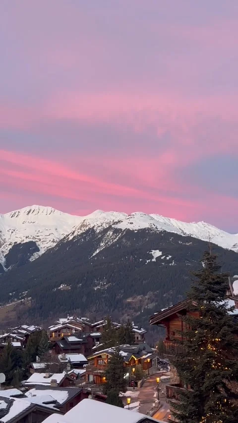 Pink sky over snowcapped mountains in front of Courchevel ski resort. Stock Footage 334404258