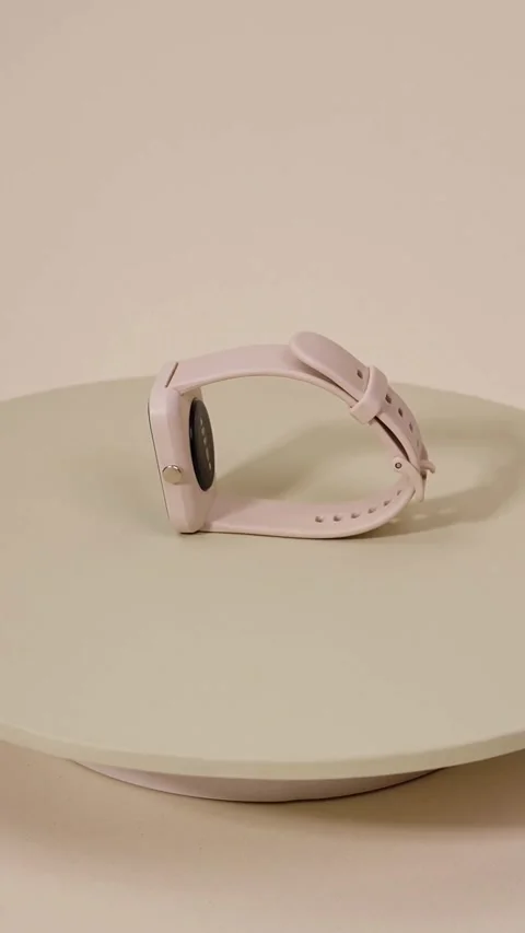 Pink smartwatch rotating on a platform with neutral background Vídeos de archivo 331773653