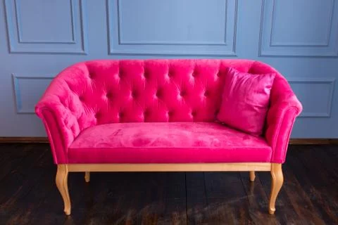 Pink sofa on a blue wall background Stock Photos