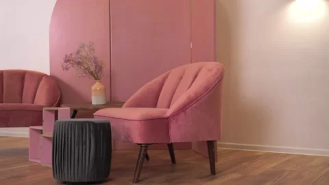 Pink soft chairs stand against the background folding wall in stylish interior Stock Footage 164961876