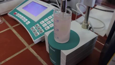The pink solution is stirred in a laboratory flask Stock Footage 128374618