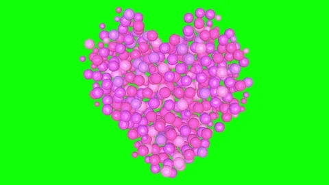 Pink spheres tumble down to form a heart - green background. Stock Footage 71764434