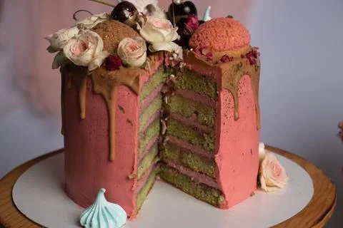 Pink sponge cake with a slice cut off. The cake is beautifully decorated with Stock Photos