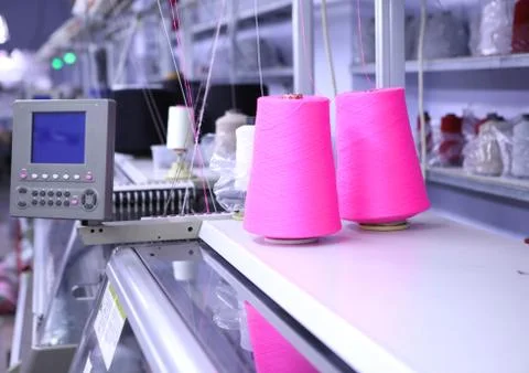 Pink spools of thread on the background of the sewing workshop. Clothing Stock Photos