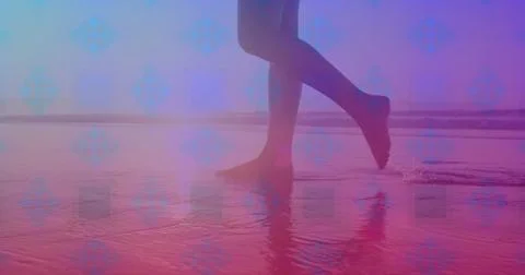 Pink square design pattern against low section of a woman walking on the beach Stock Photos