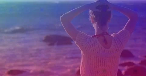 Pink square design pattern against rear view of caucasian woman standing on the Stock Photos