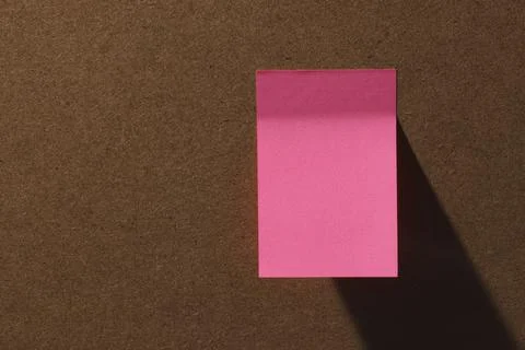 Pink square office sticky notes on cork board with hard shadow Stock Photos