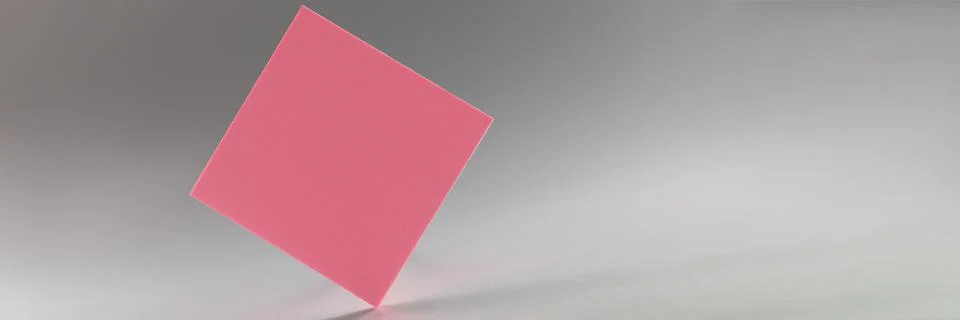 Pink square sticker standing on sharp edge on grey background Stock Photos
