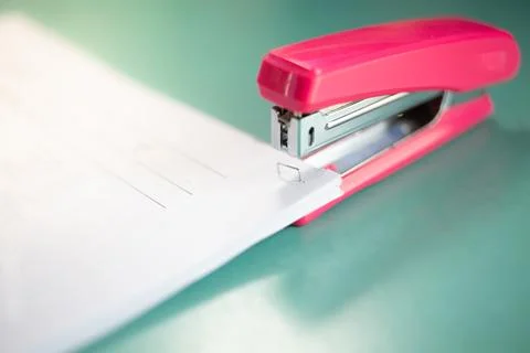 The pink stapler does not pierce through many sheets of paper.shallow focus.. Stock Photos