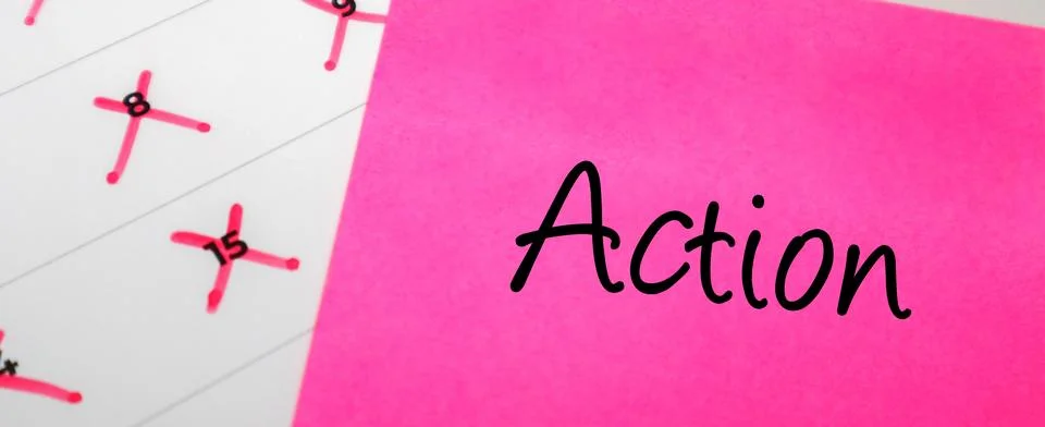 Pink sticky note with Action text on a calendar with red marked dates. Conc.. Stock Photos