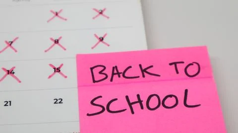 A pink sticky note with "BACK TO SCHOOL" written in bold letters is placed .. Stock Photos