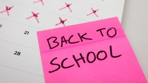 A pink sticky note with "BACK TO SCHOOL" written in bold letters is placed .. Stock Photos