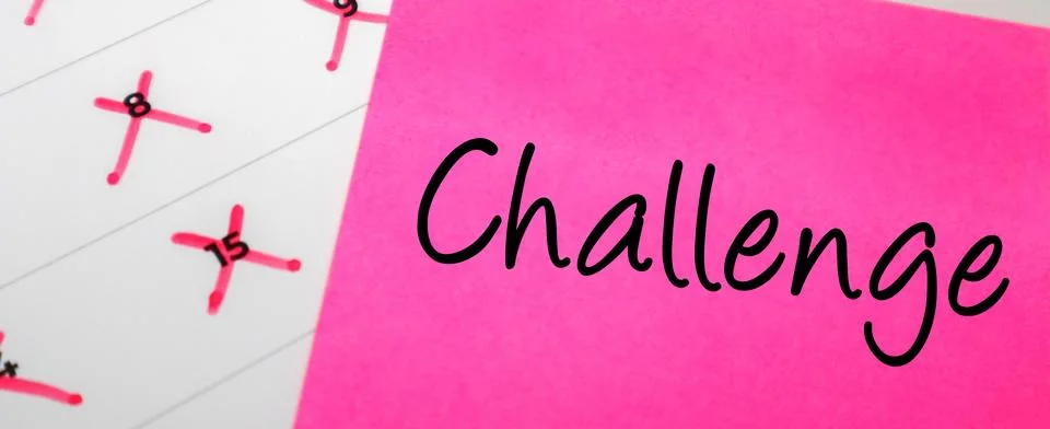 Pink sticky note with Challenge text on a calendar with red marked dates. C.. Stock Photos