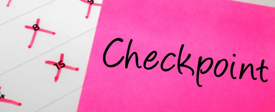 Pink sticky note with Checkpoint text on a calendar with red marked dates. .. Stock Photos