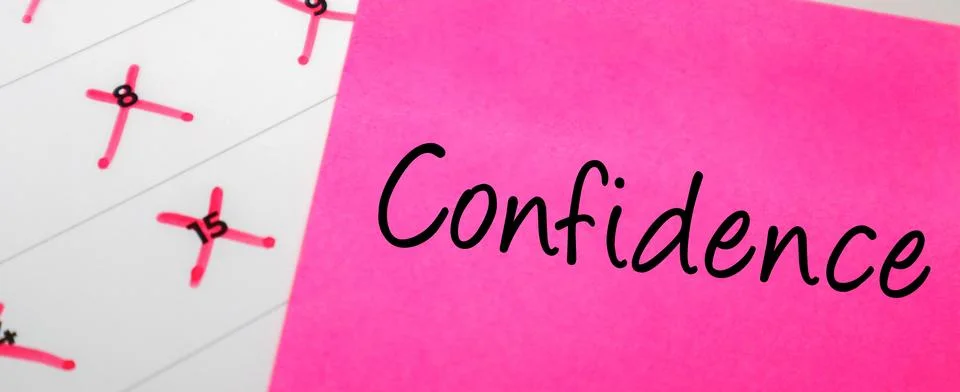 Pink sticky note with Confidence text on a calendar with red marked dates. .. Stock Photos