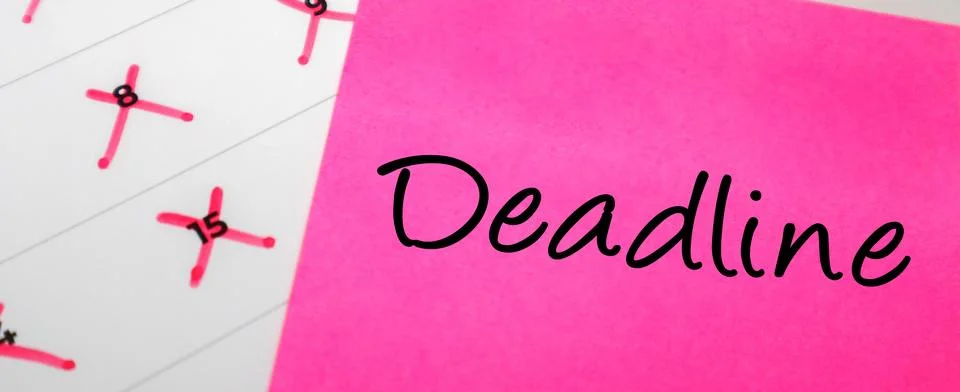 Pink sticky note with Deadline text over a calendar with dates crossed out .. Stock Photos