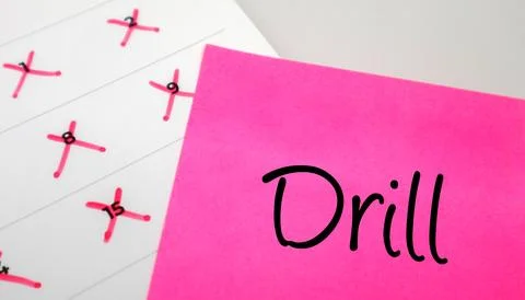 Pink sticky note with Drill text on a calendar with red marked dates. Conce.. Stock Photos