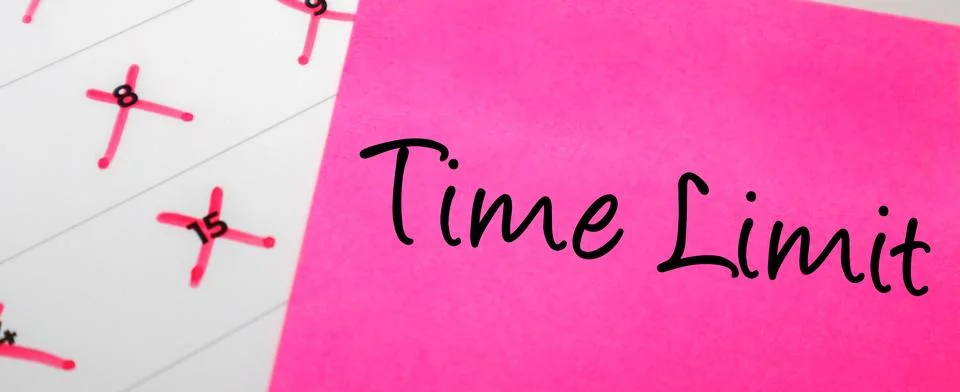 Pink sticky note with Time Limit text over a paper calendar with specific d.. Stock Photos