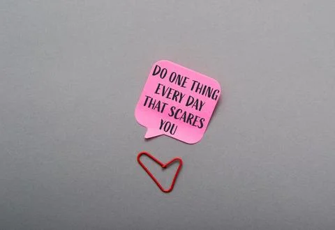 A pink sticky note with the words Do one thing every day that scares you Foto stock