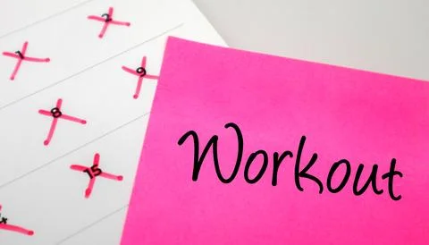 Pink sticky note with Workout text on a calendar with red marked dates. Con.. Stock-Fotos