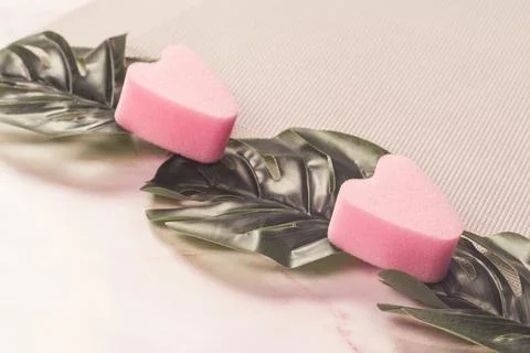 Pink stringless tampons on monstera sheets. Stock Photos