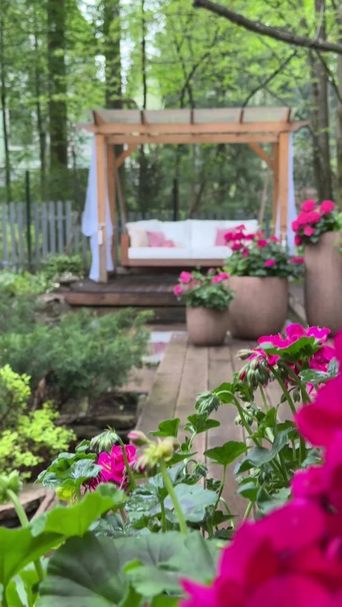 Pink Summer Flowers Framing Cozy Outdoor Garden Swing Video stock 334889088