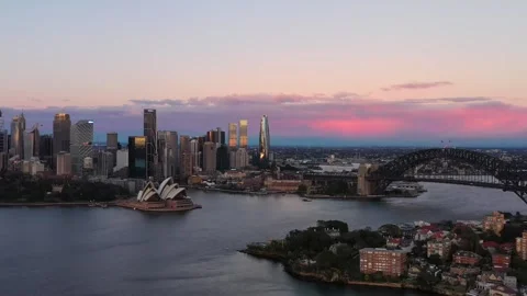 Pink sunrise clouds over Sydney city CBD landmarks on harbour – aerial 4k fly. Stock Footage 293131718