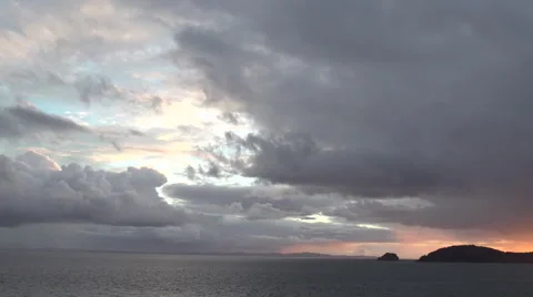 Pink sunset behind Islands with light blue sky breaking in clouds Stock Footage 65505974