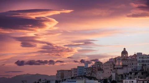 Pink sunset with clouds drawn by the wind in Cagliari Stock Photos