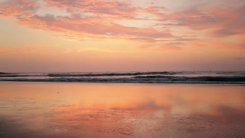 Pink Sunset over Calm Ocean Waves with Vibrant Cloud Reflections Stock Footage 344163268