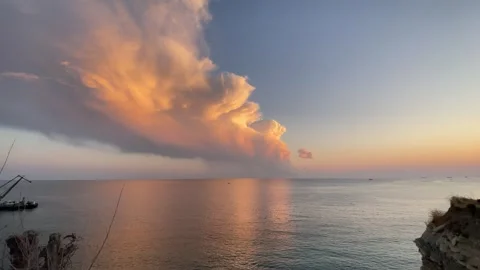 Pink sunset over the calm sea with dramatic clouds reflecting in the water Stock Footage 293065415