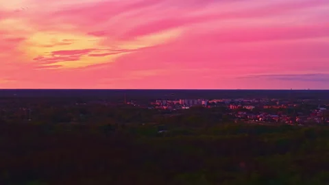 Pink sunset over cityscape under dramatic sky, drone video Stock Footage 310977591