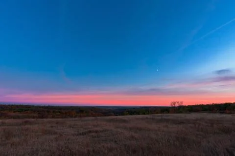 Pink sunset over the fields with stripes from the aircraft. night photo, long Stock Photos