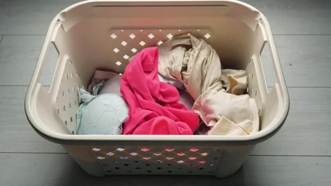 Pink T-shirt in a stack of light linen. Home life concept Video stock 130710638