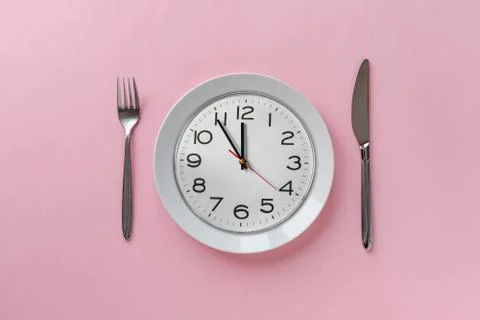 Pink table setting with clock on a plate Stock Photos