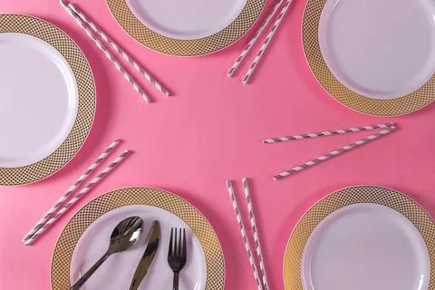 Pink table setting pattern with plates and striped straws Stock Photos