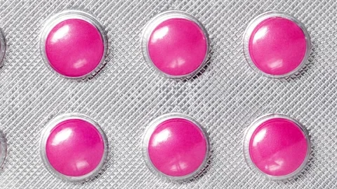 Pink tablets in blister moving sideways, close-up 스톡 동영상 240655449