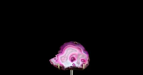 Pink tainted agate slice on support Stock Photos