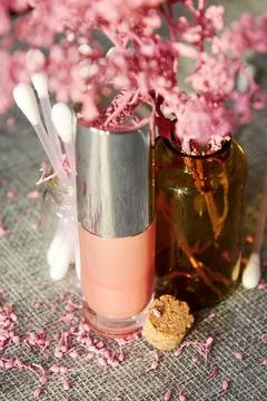 Pink tiny lip gloss jar with other cosmetics tubes on the makeup store desk Stock Photos