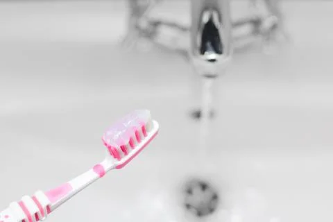 Pink toothbrush with toothpaste. Small depth of field. Stock Photos